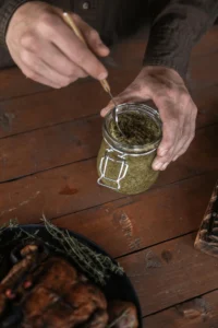 Naturopath preparing herbal remedy in a glass jar for natural health support